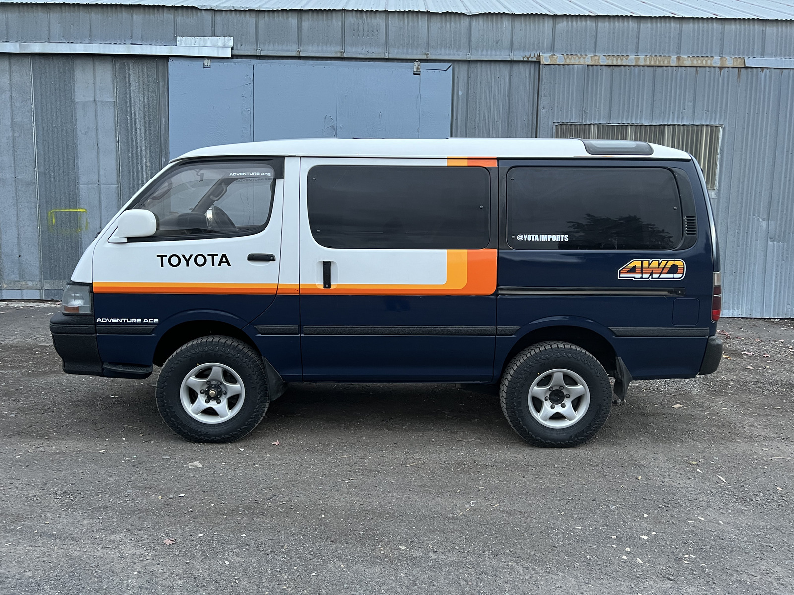 Navy Adventure Ace van parked by warehouse
