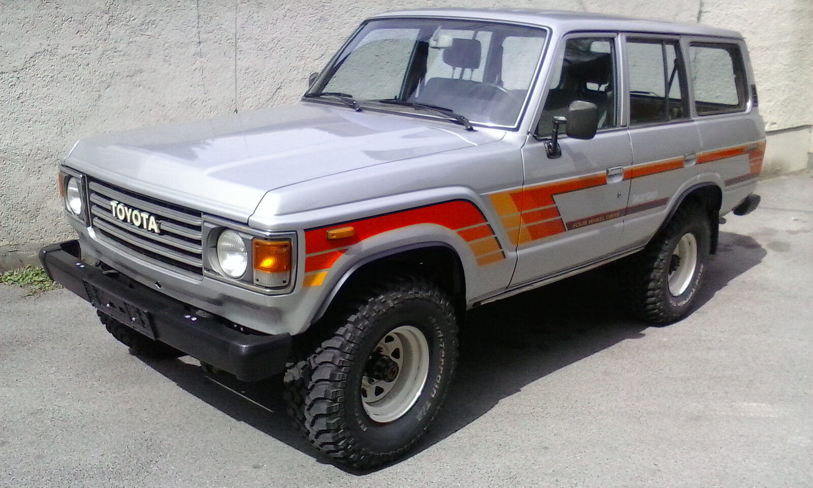 60 Series Land Cruiser in red dirt with dog riding along
