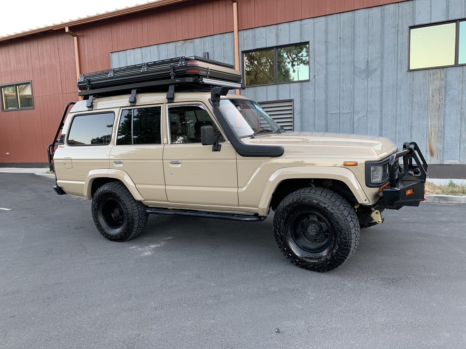 Tan 60 Series Land Cruiser with roof rack and light bar