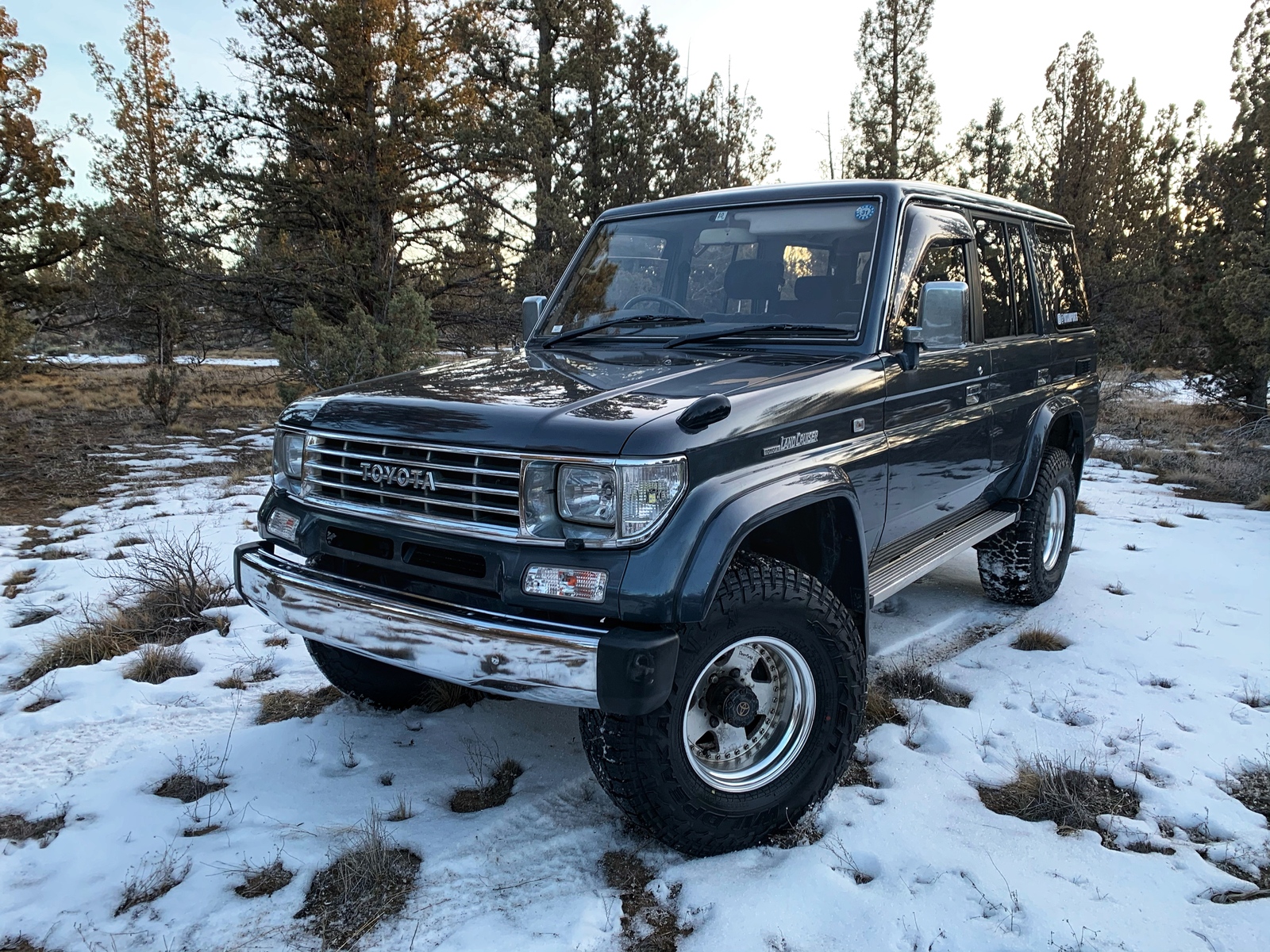 Tan Prado Land Cruiser parked by a graffiti train car
